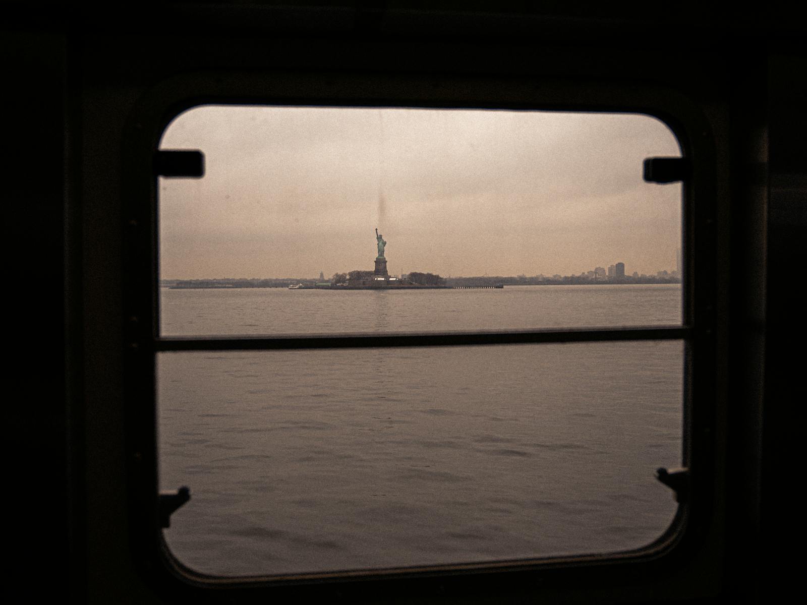 Statue of Liberty seen through a ferry window in New York Harbor