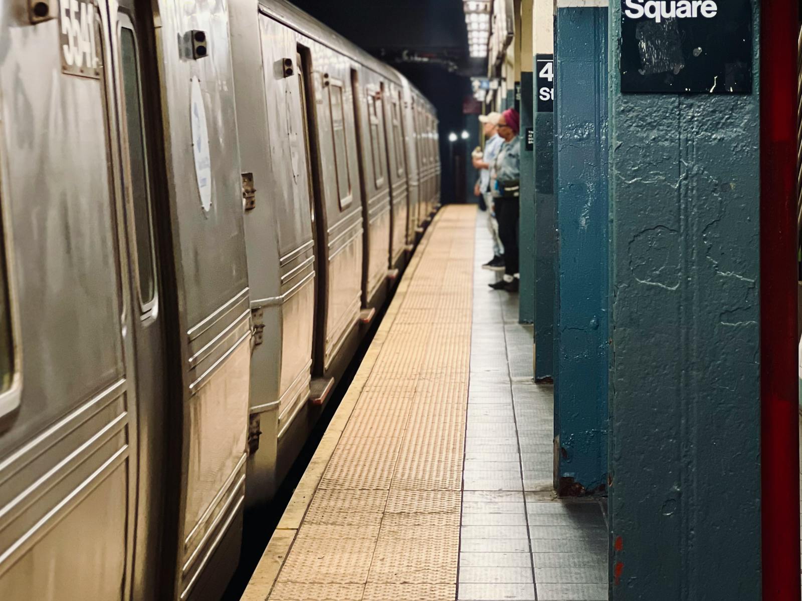 Times Square subway platform with a train and passengers in New York